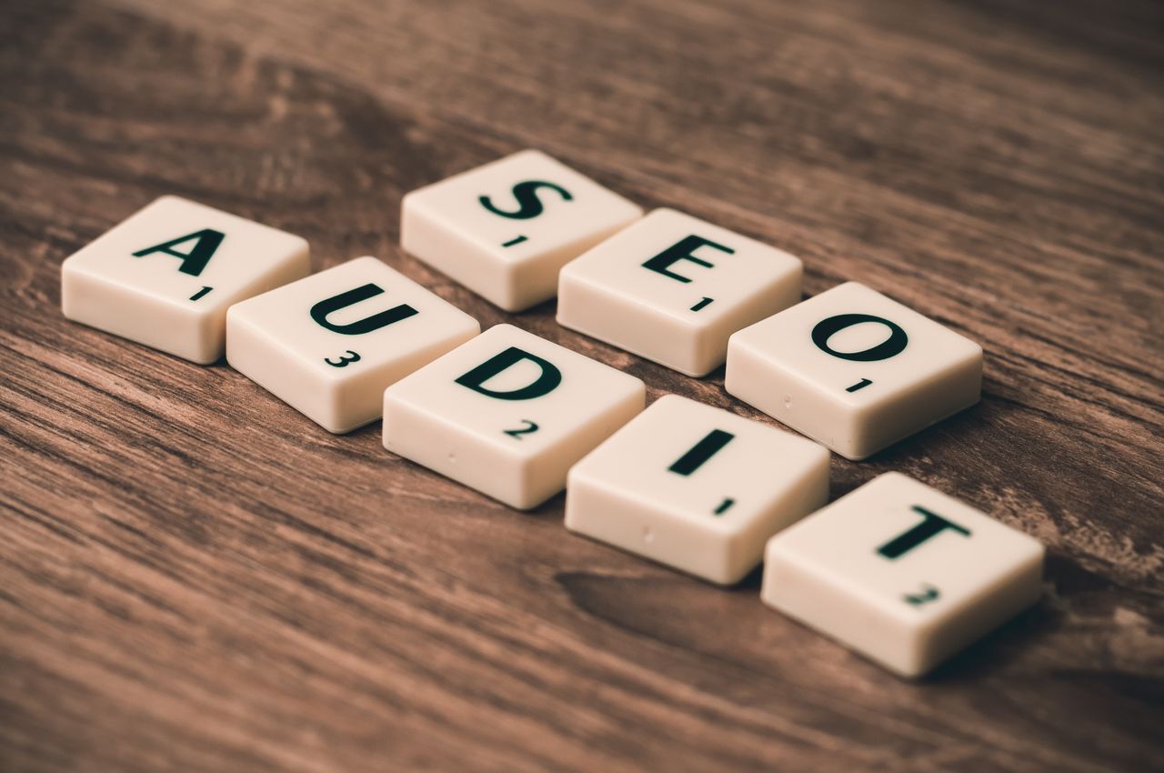 services-02 Scrabble tiles spelling SEO Audit on wooden surface, symbolizing digital marketing strategies.