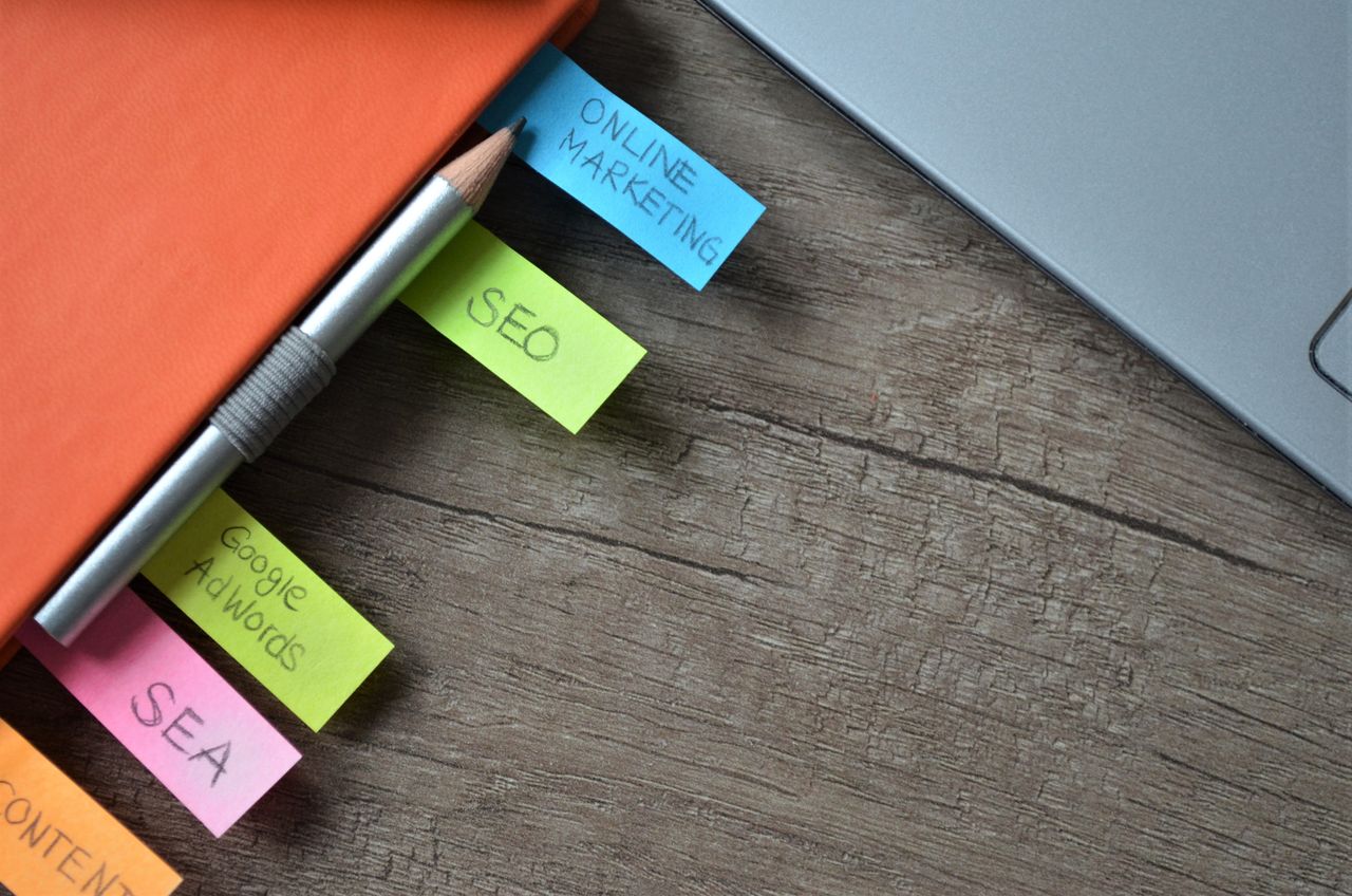 team-03 Close-up of SEO strategy planner with colorful sticky notes and a pencil on a notebook.